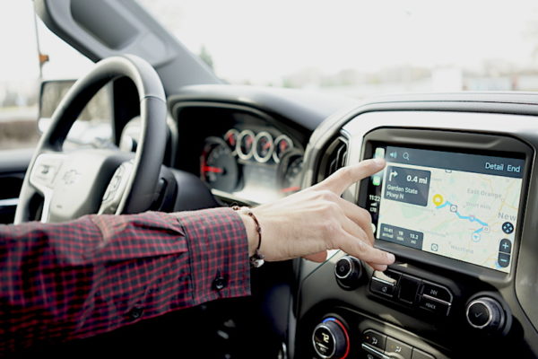 Driver Using Infotainment Screen To Navigate Apple Carplay