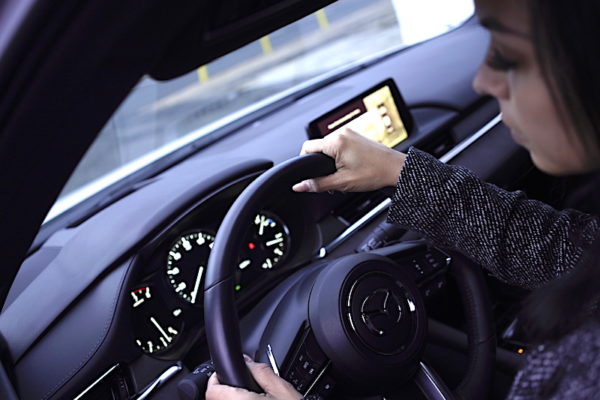 Woman Steering The Mazda 6 With Apple Carplay Displayed On The Center Screen