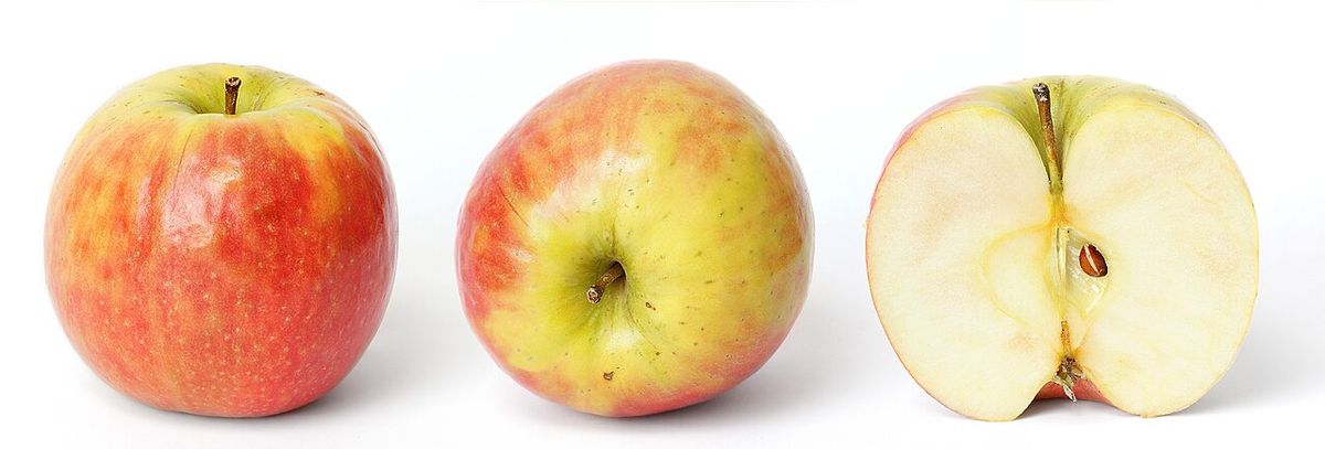 Dos manzanas enteras y una partida a la mitad sobre fondo blanco.