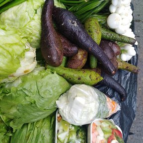 Puesto de verduras con chinines morados entre lechugas, cebollas y chiles.