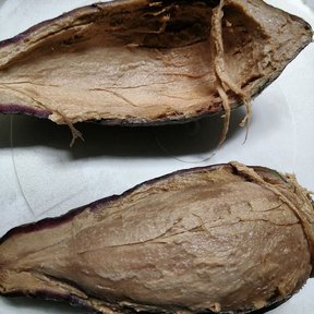 Dos mitades de chinine sobre un plato, con la cáscara morada y la pulpa clara.