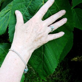 Una mano apoyada sobre una hoja de tilia para dar la escala.